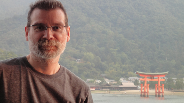 selfie with torii gate and shore in the distance